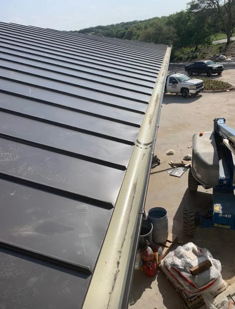 Standing seam panel and gutter detail on a metal roofing jobsite in Harrison